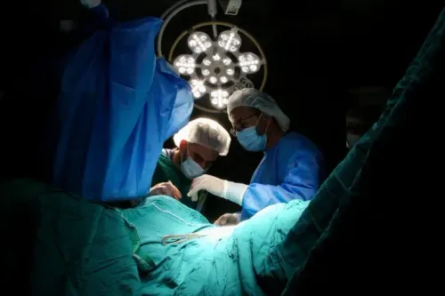 أطباء يجريون عملية جراحية في ظروف صعبة بمستشفى ناصر في غزة، وسط نقص حاد في الوقود والموارد الطبية.