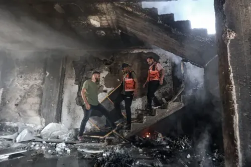 رجال إنقاذ يرتقون الدرج في مبنى مدمر بعد الهجمات الإسرائيلية على غزة، مع وجود دخان وحطام حولهم.