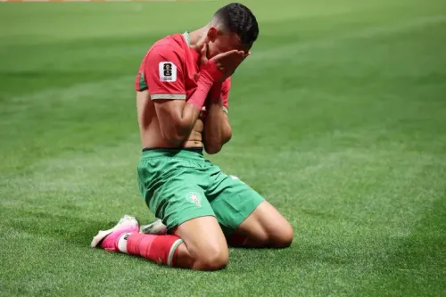 لاعب مغربي يجلس على الأرض بعد المباراة، مغطياً وجهه بيديه، معبراً عن مشاعر مختلطة بعد الفوز 4-2 على هايتي في كأس العالم.