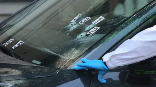 فريق الطب الشرعي يفحص سيارة تعرضت لإطلاق نار، مع وجود ثقوب في الزجاج الأمامي، في موقع هجوم على مسؤولين في مكسيكو سيتي.