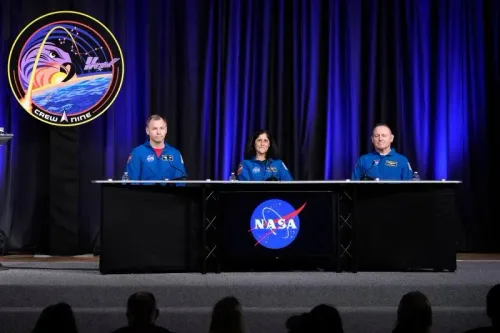 مؤتمر صحفي لرواد الفضاء ويليامز، ويلمور، وهيغ، يتحدثون عن تجربتهم في مهمة كرو-9 مع شعار ناسا خلفهم.