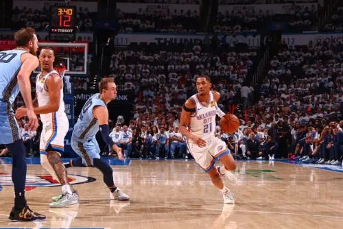 لاعب من فريق أوكلاهوما سيتي ثاندر يحمل الكرة أثناء مباراة ضد ممفيس جريزليز، مع وجود الجماهير في الخلفية.