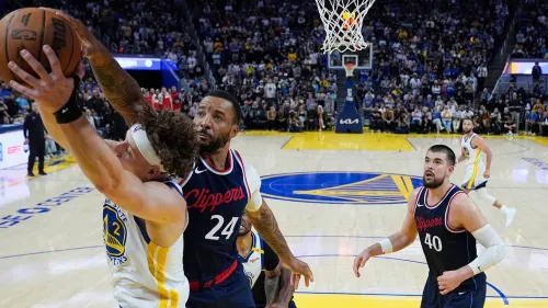 لاعب من فريق لوس أنجلوس كليبرز يتصدى للاعب من فريق جولدن ستيت ووريورز أثناء مباراة حاسمة في دوري كرة السلة الأمريكي للمحترفين.