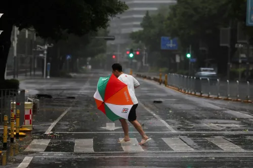 رجل يحمل مظلة ملونة ويتحرك عبر شارع مهجور أثناء هطول أمطار غزيرة نتيجة إعصار راغاسا في جنوب الصين.