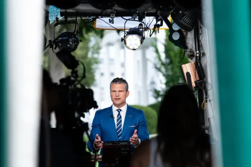 مراسل يتحدث أمام الكاميرا في موقع تصوير خارجي بالقرب من البيت الأبيض، مع تسليط الضوء على أهمية الدعم العسكري لأوكرانيا.