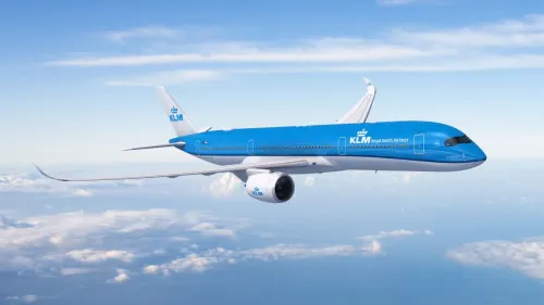 طائرة KLM الحديثة من طراز Airbus A350 تحلق فوق السحب، تمثل التحديات التنظيمية في اعتماد أجنحة درجة رجال الأعمال الفاخرة.