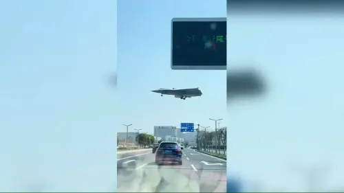 طائرة J-36 الصينية المقاتلة ذات الثلاثة محركات تحلق فوق طريق سريع بالقرب من مصنع تشنغدو، تظهر تصميمها المتقدم وتقنيات التخفي.