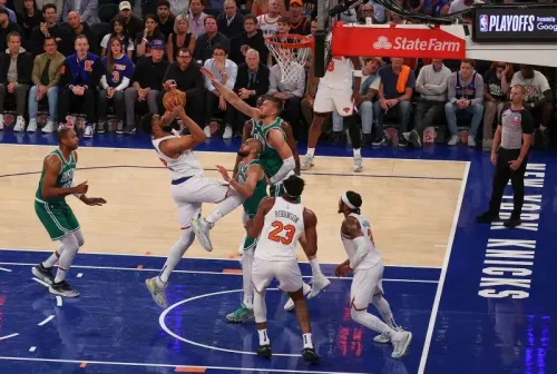 لاعب من نيويورك نيكس يسجل نقطة خلال مباراة حماسية ضد بوسطن سيلتيكس في نهائي البطولة الشرقية، مع حضور جماهيري كبير.