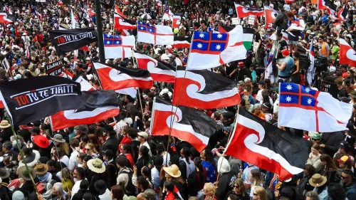 مظاهرة حاشدة لمجتمع الماوري في نيوزيلندا، حيث ترفرف أعلام تحمل شعار "توتو تي تيريتى"، تعبيرًا عن الاحتجاج ضد مشروع قانون يهدد حقوقهم.