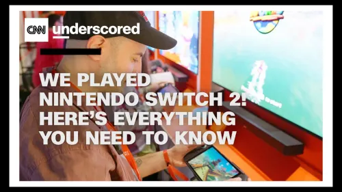 رجل يجرب جهاز نينتندو سويتش 2 في حدث ترويجي، مع شاشة عرض خلفه تعرض لعبة جديدة، مما يعكس الحماس حول الإصدار.