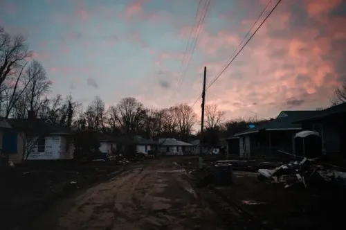 مشهد لشارع في منطقة متضررة بإعصار هيلين، يظهر منازل مدمرة وحطام متناثر تحت سماء غائمة، مما يعكس آثار الكارثة.