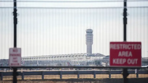 مطار ريغان الوطني يبرز في الخلفية مع برج المراقبة، بينما تظهر لافتات تحذيرية تشير إلى مناطق محظورة.