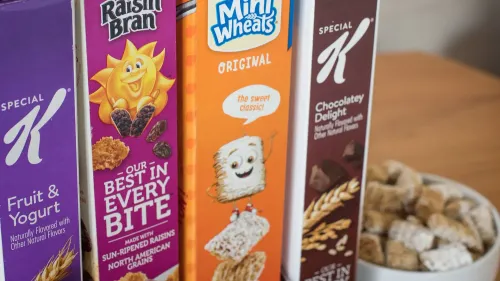 عبوات حبوب الإفطار الشهيرة "رايزن بران" و"ميني ويتس" و"تشوكليت ديلايت" من شركة WK Kellogg، مع وعاء من الحبوب في الخلفية.