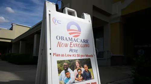 لافتة تشير إلى التسجيل في برنامج أوباما كير، تعرض عائلة سعيدة، مع معلومات عن خطط تأمينية بأسعار منخفضة.