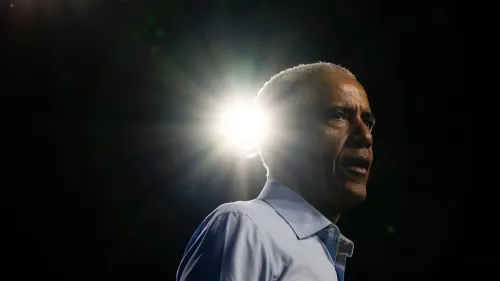 باراك أوباما يتحدث في منتدى كونيتيكت، مع إضاءة خلفية، مشدداً على أهمية الدفاع عن الديمقراطية في ظل التحديات الحالية.