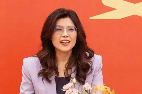 تظهر تشنغ لي وون، رئيسة حزب الكومينتانغ، مبتسمة أثناء حديثها في مؤتمر صحفي، مع خلفية حمراء تعكس أجواء سياسية مهمة.