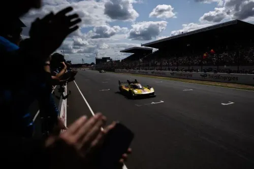 روبرت كوبيكا يقود سيارة سباق خلال سباق لومان 24 ساعة، وسط حشد من المشجعين، بعد تحقيقه فوزاً تاريخياً في رياضة السيارات.