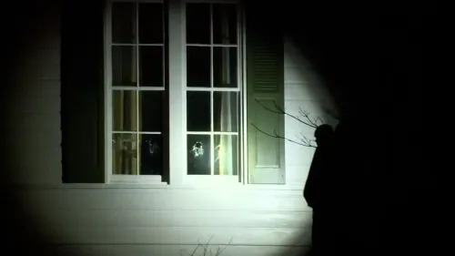 أضرار واضحة في نوافذ منزل نائب الرئيس جيه دي فانس، مع وجود شخص بالقرب من المنزل في ظروف مظلمة، بعد حادث اقتحام محتمل.