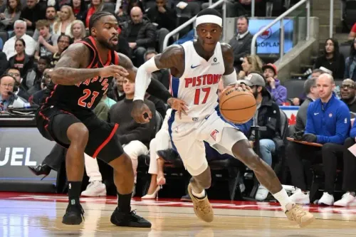 ديترويت بيستونز في مباراة ضد تورونتو رابتورز، حيث يسجل اللاعب دورين كرة سلة بينما يتصدى له لاعب رابتورز.