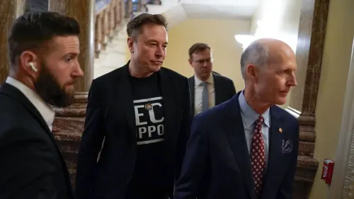 إيلون ماسك يتحدث مع المشرعين في الكابيتول هيل، محاطًا بحراسه الشخصيين، في سياق مناقشات حول برامج الفيدرالية.