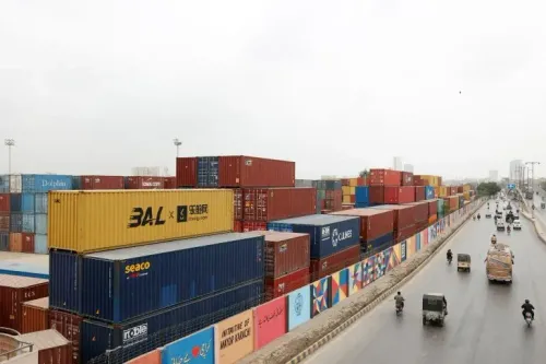 صورة تظهر حاويات شحن ملونة مرتبة في ميناء كراتشي، مع حركة مرور نشطة على الطريق المجاور، تعكس زيادة التجارة الإقليمية بين باكستان وإيران.
