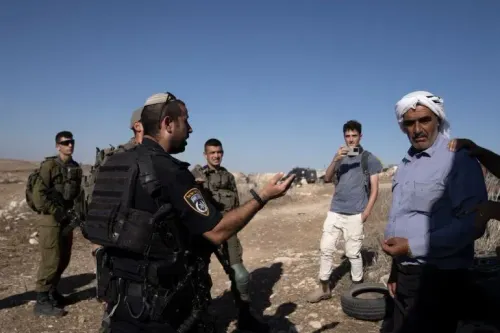 جنود إسرائيليون يتحدثون مع فلسطيني في مسافر يطا، حيث يتعرض المواطنون للتهديد بالطرد من أراضيهم بسبب ممارسات الاستيطان.