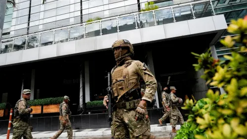 وجود جنود مسلحين يرتدون زيًا عسكريًا في شارع بالقرب من مبنى حكومي في بنما، مما يعكس الوضع الأمني المتوتر في البلاد.