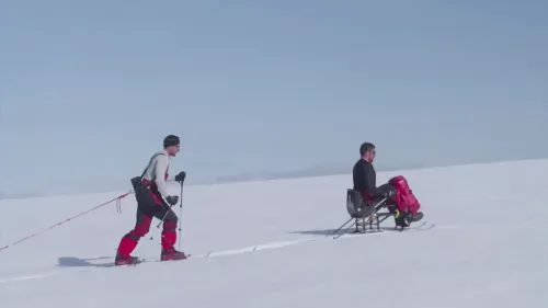 دارين إدواردز يتزلج باستخدام زلاجة جلوس بينما يسحبه صديقه عبر الثلوج في القارة القطبية الجنوبية، مظهرًا تحدياته كأحد المغامرين المعاقين.