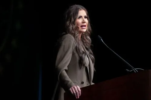 امرأة تتحدث على منصة، تعبر عن قلقها بشأن تأثير مشاركة البيانات الضريبية على المهاجرين غير الموثقين في الولايات المتحدة.