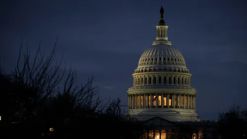 قبة مبنى الكابيتول الأمريكي مضاءة في المساء، محاطة بأشجار عارية، تعكس أهمية التعديلات الدستورية والنقاشات السياسية الجارية.