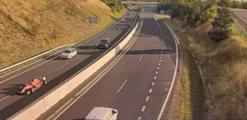 سيارة سباق حمراء تسير بسرعة على طريق سريع في جمهورية التشيك، وسط سيارات أخرى، مما يشير إلى حالة قانونية مثيرة.