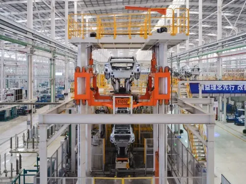 صورة توضح خط إنتاج سيارات كهربائية في مصنع BYD، يظهر فيه هيكل سيارة مع وجود آلات صناعية متطورة، مما يعكس التحول نحو الأتمتة في التصنيع.