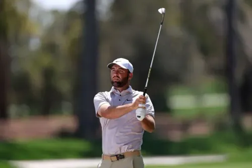 لاعب الغولف ج. ج. سباون في ملعب TPC Sawgrass، يستعد لتسديدة مهمة خلال جولة بطولة اللاعبين، وسط أجواء عاصفة.