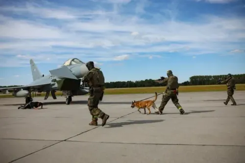 عناصر من الجيش البولندي يقومون بعمليات أمنية على مدرج مطار، مع وجود طائرة مقاتلة في الخلفية، في إطار تعزيز الدفاعات الجوية.