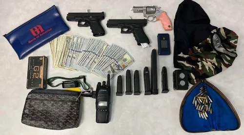 عناصر مسروقة تشمل أسلحة نارية، نقود، وأدوات سطو، تم استردادها خلال عملية للشرطة في لوس أنجلوس ضد عصابة سطو.