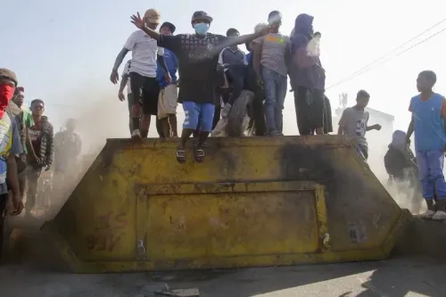 محتجون يقفون فوق حاوية نفايات خلال مظاهرة مناهضة للحكومة في مدغشقر، حيث تصاعدت التوترات بسبب الفساد وانقطاع الكهرباء.