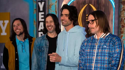 أعضاء فرقة The All-American Rejects يظهرون في حدث، مبتسمين ويتفاعلون مع الجمهور، مع خلفية ملونة تعكس أجواء موسيقى الإيمو.