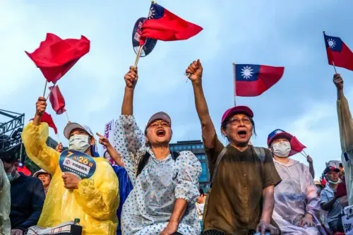 محتجون يحملون أعلام تايوانية ويرفعون أصواتهم خلال تجمع انتخابي، معبرين عن دعمهم للحزب الديمقراطي التقدمي.