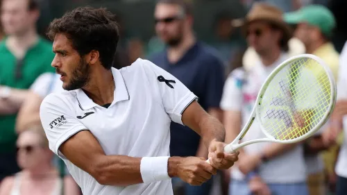 لاعب التنس البرتغالي فرانسيسكو كابرال يرتدي شريطًا أسود على ملابسه البيضاء تكريمًا للراحل ديوغو جوتا، وسط جمهور في ويمبلدون.