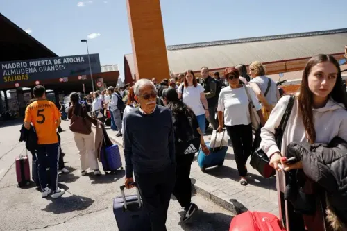 ازدحام كبير أمام محطة قطارات "مدريد بويرتا دي أتوتشا"، حيث ينتظر المسافرون مع حقائبهم بعد انقطاع التيار الكهربائي.