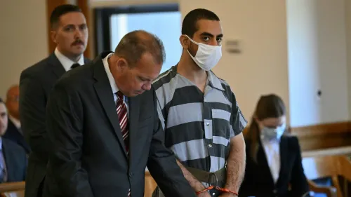 مطر، المتهم بمحاولة قتل رشدي، يقف في قاعة المحكمة مرتديًا زي السجن، بينما يستمع محاميه.