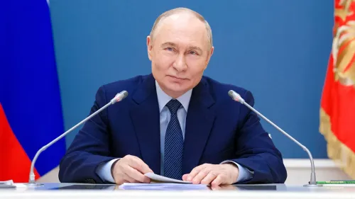 صورة للرئيس الروسي فلاديمير بوتين وهو يجلس أمام ميكروفونات، مع العلم الروسي في الخلفية، يعكس موقف موسكو المتصلب في محادثات السلام مع أوكرانيا.