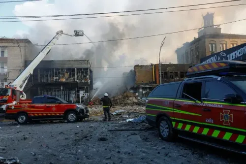 دخان يتصاعد من مبنى مدمر في كييف بعد هجوم بطائرات مسيرة، بينما رجال الإطفاء يعملون على إخماد النيران.