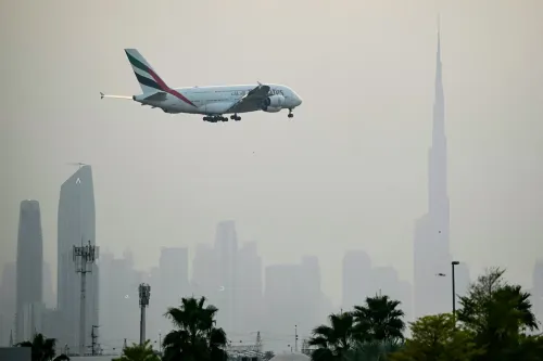 طائرة إيرباص A380 تابعة لطيران الإمارات تحلق فوق أفق دبي مع برج خليفة في الخلفية، تعكس أهمية الطائرة في صناعة الطيران الفاخر الخليجية.