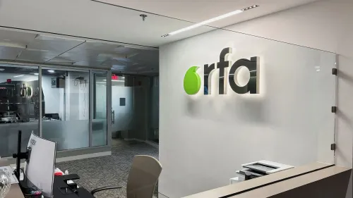 مدخل مكتب إذاعة آسيا الحرة، مع شعارها المضيء "rfa" على الجدار، يعكس التحديات التي تواجهها في ظل تقليص التمويل.