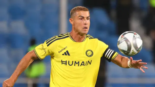 لاعب كرة قدم يرتدي قميص النصر الأصفر يركض نحو الكرة خلال مباراة دوري روشن للمحترفين.