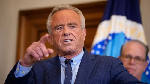 روبرت كينيدي جونيور يتحدث بجدية خلال مؤتمر صحفي، مع التركيز على قضايا إعلانات الأدوية وتأثيرها على المستهلكين.