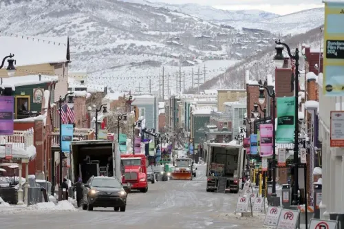 شارع مغطى بالثلوج في بارك سيتي، يوتا، مع شاحنات ومركبات تستعد لمهرجان صندانس السينمائي، الذي سينتقل إلى بولدر، كولورادو في 2027.