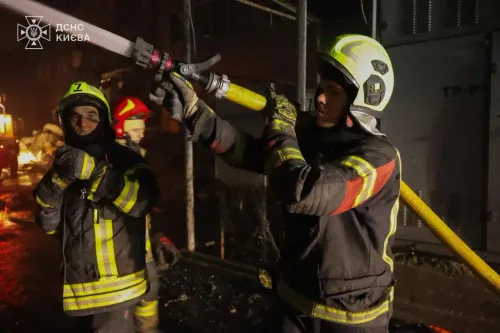 رجال الإطفاء يعملون على إخماد حريق في مبنى سكني في كييف بعد هجوم بطائرات مسيرة، مع وجود آثار الدمار في الخلفية.