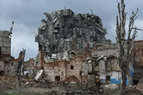 مبنى مدمر في منطقة بوكروفسك بأوكرانيا، يظهر آثار القتال العنيف بين القوات الروسية والأوكرانية، مع بقايا هياكل مهدمة وأشجار جافة.